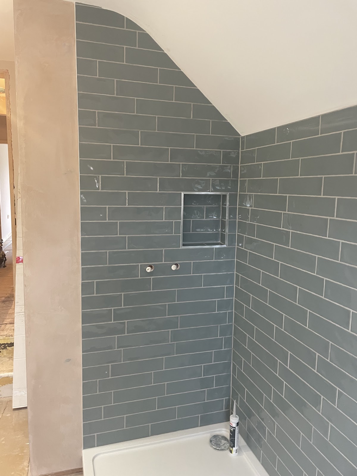 Slate-grey brick-effect shower tiling with a built-in niche shelf